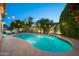 Inviting backyard pool with lush landscaping and string lights, ideal for evening relaxation and entertainment at 16238 N 58Th St, Scottsdale, AZ 85254