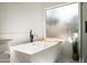 Close up of a luxurious soaking tub with modern fixtures and a view from a window at 16238 N 58Th St, Scottsdale, AZ 85254