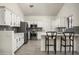 A modern kitchen with stainless steel appliances, white cabinets, and a functional breakfast bar at 16238 N 58Th St, Scottsdale, AZ 85254