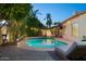 Sparkling pool with a sunning chair amidst lush landscaping and subtle string lighting at 16238 N 58Th St, Scottsdale, AZ 85254