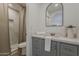 Modern bathroom with gray vanity, framed arched mirror, and tiled shower with contemporary neutral curtain at 16421 N 34Th Ave, Phoenix, AZ 85053