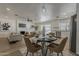 Open-concept dining area with modern table and seating, adjacent to a living room with fireplace and updated kitchen at 16421 N 34Th Ave, Phoenix, AZ 85053