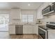Bright kitchen featuring white cabinets, stainless steel appliances, and a view of the back patio through a window at 16421 N 34Th Ave, Phoenix, AZ 85053
