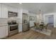 Modern kitchen with white cabinets, stainless steel appliances, and open layout to a dining space with seating at 16421 N 34Th Ave, Phoenix, AZ 85053