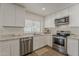 Updated kitchen with stainless steel appliances, white cabinets, stone countertops, and ample natural light at 16421 N 34Th Ave, Phoenix, AZ 85053