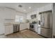 Modern kitchen featuring stainless steel appliances, white cabinets, and ample counter space at 16421 N 34Th Ave, Phoenix, AZ 85053