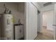 Well-lit laundry room area with a water heater, sink, and storage underneath, with an open doorway to the rest of the house at 16421 N 34Th Ave, Phoenix, AZ 85053