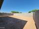 Large dirt backyard surrounded by block fencing, offering privacy and potential at 19406 N Fiano Dr, Maricopa, AZ 85138