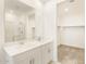 Bright bathroom featuring dual sinks, a walk-in shower with glass door, and a walk-in closet at 19406 N Fiano Dr, Maricopa, AZ 85138