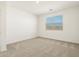 Well-lit bedroom features soft carpet and a view through the window at 19406 N Fiano Dr, Maricopa, AZ 85138