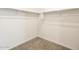 Walk-in closet featuring wall-mounted shelving and neutral carpet at 19406 N Fiano Dr, Maricopa, AZ 85138
