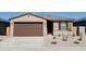 Charming single-story home with a brown garage door, well-maintained landscaping, and stone accents at 19406 N Fiano Dr, Maricopa, AZ 85138