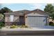 Charming single-story home featuring a gray garage door, stone accents, and a neatly landscaped front yard at 19406 N Fiano Dr, Maricopa, AZ 85138