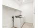 Bright laundry room featuring modern appliances and convenient shelf storage at 19406 N Fiano Dr, Maricopa, AZ 85138