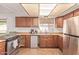 Bright kitchen with wood cabinets, tile floors, and stainless steel oven and refrigerator at 19407 N 15Th Ave, Phoenix, AZ 85027