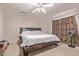 Bedroom features dark wood bed frame, neutral carpet, and ceiling fan at 19407 N 15Th Ave, Phoenix, AZ 85027