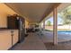 Covered patio area with outdoor kitchen and seating near the pool at 19407 N 15Th Ave, Phoenix, AZ 85027