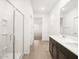 Modern bathroom with dual sinks, glass shower, and access to bedrooms at 19438 N Fiano Dr, Maricopa, AZ 85138