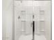 Glass enclosed shower with built-in shelving and chrome fixtures at 19438 N Fiano Dr, Maricopa, AZ 85138