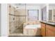 Bathroom features tile, a glass shower, a soaking tub, and a wood cabinet at 2109 W Wildhorse Dr, Chandler, AZ 85286