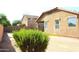 Home's backyard with gravel, bush, red fence, and a covered patio in the background at 21433 E Calle De Flores Ct, Queen Creek, AZ 85142