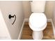 Close-up of a white toilet with wood-style flooring and a black towel holder at 21433 E Calle De Flores Ct, Queen Creek, AZ 85142