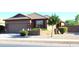 Charming single-story home with desert landscaping, tan stucco and brick accents at 21433 E Calle De Flores Ct, Queen Creek, AZ 85142