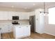 Bright kitchen features white cabinets, stainless steel appliances, quartz countertops and an island with a modern lighting fixture at 21433 E Calle De Flores Ct, Queen Creek, AZ 85142