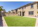 Large backyard with artificial grass, desert landscaping, and covered patio at 3064 E Michelle Way, Gilbert, AZ 85234