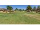 Expansive green space in a residential area with mature trees and landscaping features and colorful flowers in the background at 3064 E Michelle Way, Gilbert, AZ 85234