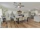 Dining room featuring wood flooring, a large wood table with white chairs, and a ceiling fan at 3064 E Michelle Way, Gilbert, AZ 85234