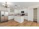 Bright kitchen with stainless steel appliances, white cabinets, an island and hardwood floors creating a modern space at 3064 E Michelle Way, Gilbert, AZ 85234