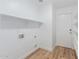 Functional laundry room featuring wood-look floors, a utility sink, and plenty of shelving at 3064 E Michelle Way, Gilbert, AZ 85234