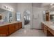 Bright bathroom with double sinks, oak cabinets, and a connecting archway to the bedroom at 3227 W Kristal Way, Phoenix, AZ 85027