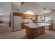 Well-lit kitchen featuring wood cabinetry, a center island with counter space, and views into the adjacent living space at 3227 W Kristal Way, Phoenix, AZ 85027
