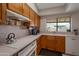 Kitchen featuring oak cabinets, white countertops, a window, and white appliances at 3227 W Kristal Way, Phoenix, AZ 85027