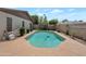 Backyard pool with clean, blue water, and a well-maintained deck surrounded by mature trees and plants at 3227 W Kristal Way, Phoenix, AZ 85027