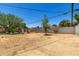 The backyard features gravel landscaping, a fire pit, mature shade trees and a block wall at 3842 W Ocotillo Rd, Phoenix, AZ 85019