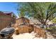 Backyard featuring a unique brick fireplace area with seating and a barbecue grill at 3842 W Ocotillo Rd, Phoenix, AZ 85019