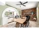 Dining room features a brick fireplace, a farmhouse-style dining table, and an archway to the living room at 3842 W Ocotillo Rd, Phoenix, AZ 85019
