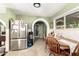 Bright kitchen with stainless steel appliances, wooden table and chairs plus an archway at 3842 W Ocotillo Rd, Phoenix, AZ 85019