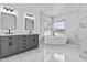 Modern main bathroom with double sinks, soaking tub, and marble tile at 38709 N 16Th Pl, Phoenix, AZ 85086