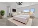 Bright bedroom boasts neutral tones, ceiling fan, and sunny view from the large windows at 38709 N 16Th Pl, Phoenix, AZ 85086