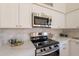 Close-up of stainless steel appliances, marble countertops and white cabinets in modern kitchen at 4037 E Milton Dr, Cave Creek, AZ 85331
