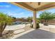 Covered patio area with ceiling fan overlooking the luxurious pool with rock waterfall feature at 4093 E Westchester Dr, Chandler, AZ 85249