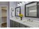 Bathroom featuring a double vanity with white countertops, dark wood cabinets, and stylish mirrors at 4093 E Westchester Dr, Chandler, AZ 85249