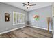 Bedroom with wood-look floors, modern ceiling fan and white shutters at 4093 E Westchester Dr, Chandler, AZ 85249