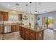 Kitchen featuring an island with granite countertops, wood cabinets, and stainless steel appliances at 4093 E Westchester Dr, Chandler, AZ 85249