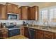 Kitchen featuring stainless steel appliances, granite countertops, and shaker style wood cabinets at 4093 E Westchester Dr, Chandler, AZ 85249
