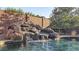 Lush backyard pool featuring a rock waterfall and a clear, refreshing swimming area at 4093 E Westchester Dr, Chandler, AZ 85249